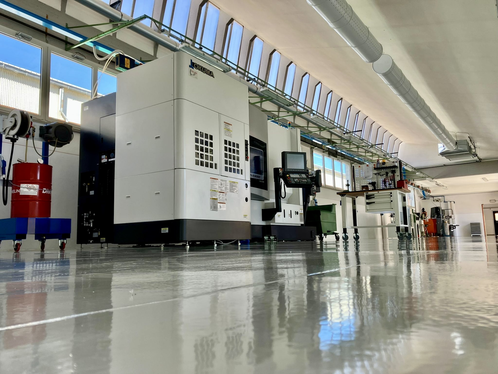 Reparto di prototipazione meccanica Benevelli con macchina CNC Okuma Multus e postazioni attrezzate per lavorazioni di precisione